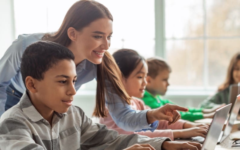 Educator and students interactively learning using Lumio in a classroom environment.