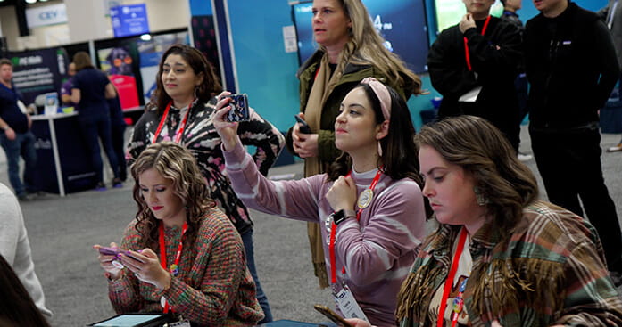 A photo of people gathering to learn about SMART Boards at an event.