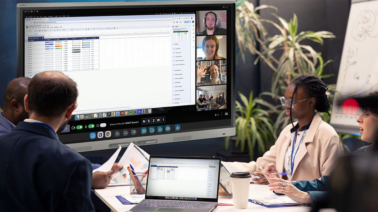 “Team in a hybrid meeting using SMART OneLaunch to share whiteboard and browser via interactive display and laptop.
